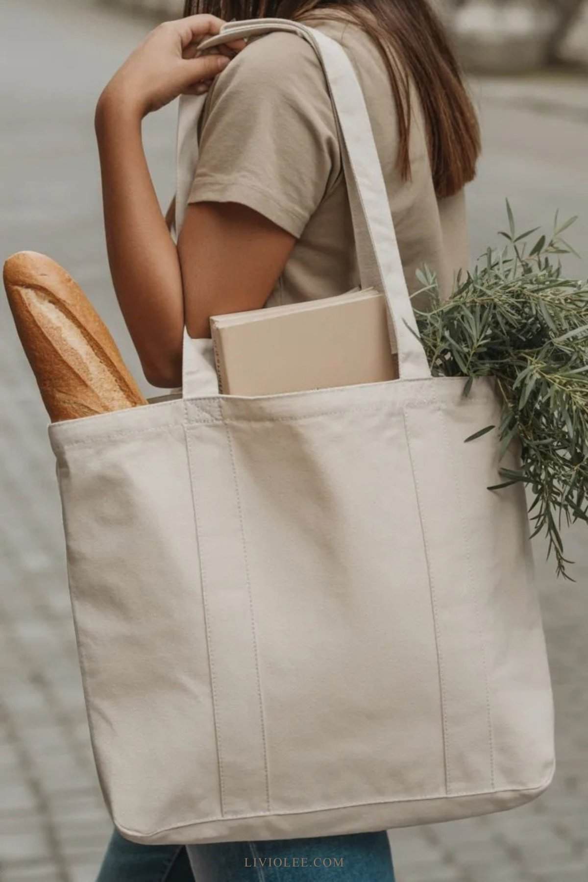 Woman carrying a simple handmade canvas tote bag filled with everyday items
