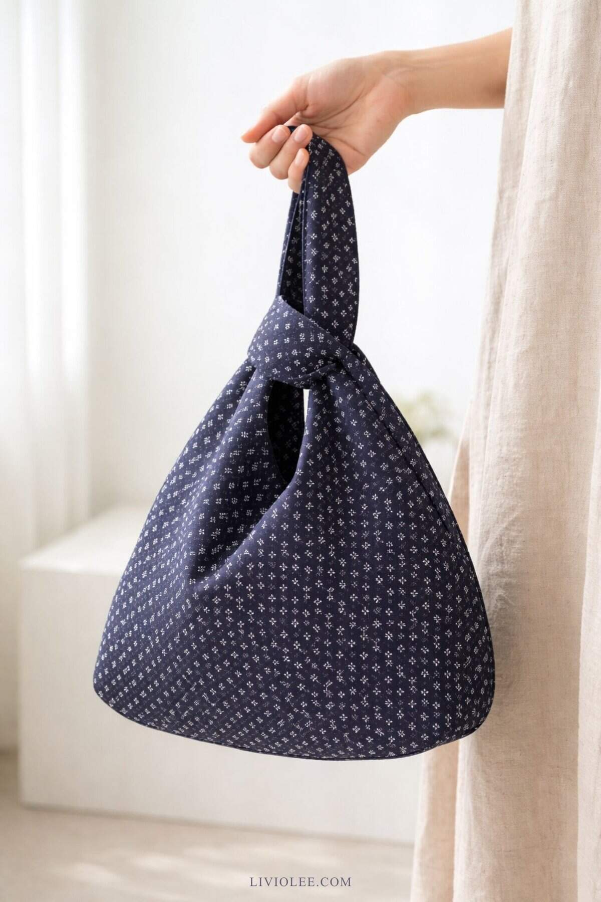japanese knot tote bag in navy geometric fabric with handle looped through