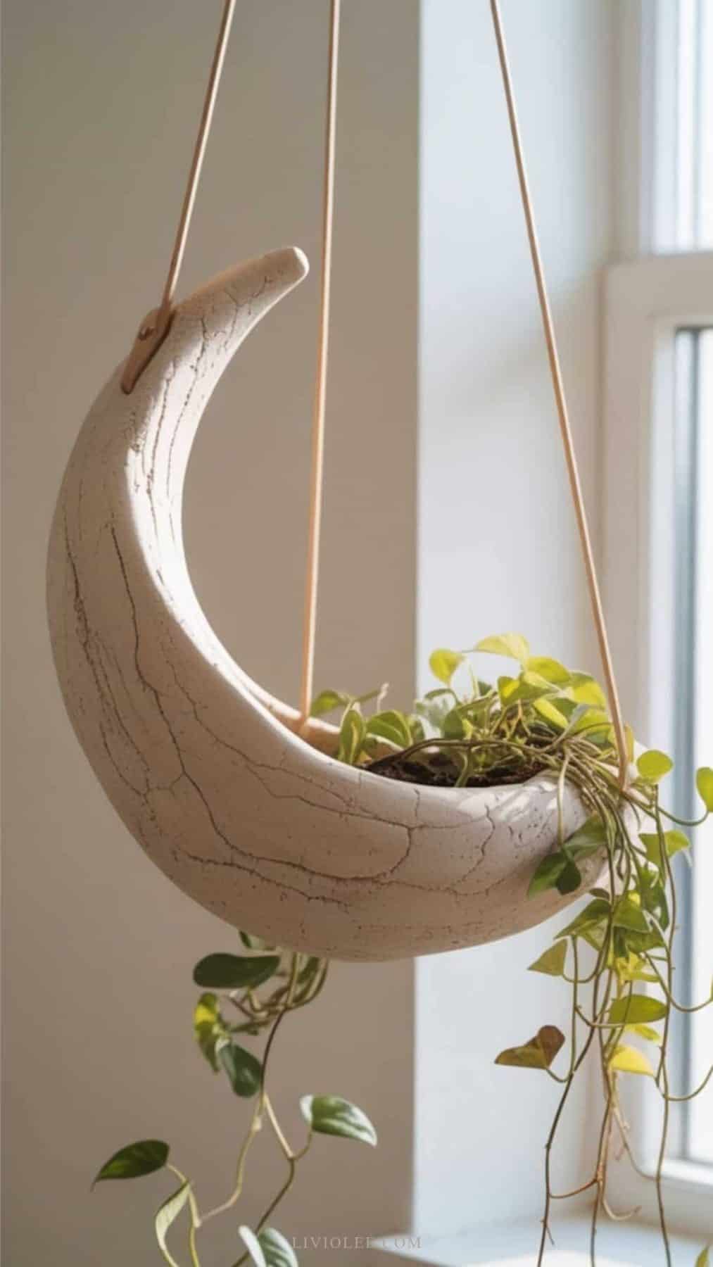 air dry clay crest hanging planter with green plant in it