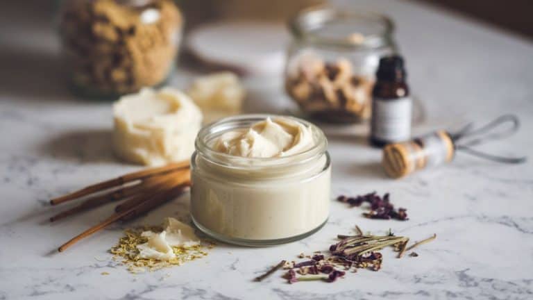 selection of tallow, jars, dried ingredients for handmade beef tallow skin care recipes