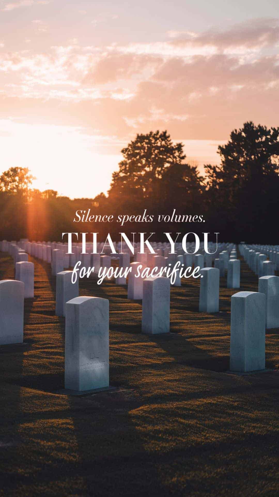 Memorial Day cemetery image at sunset featuring rows of white military headstones