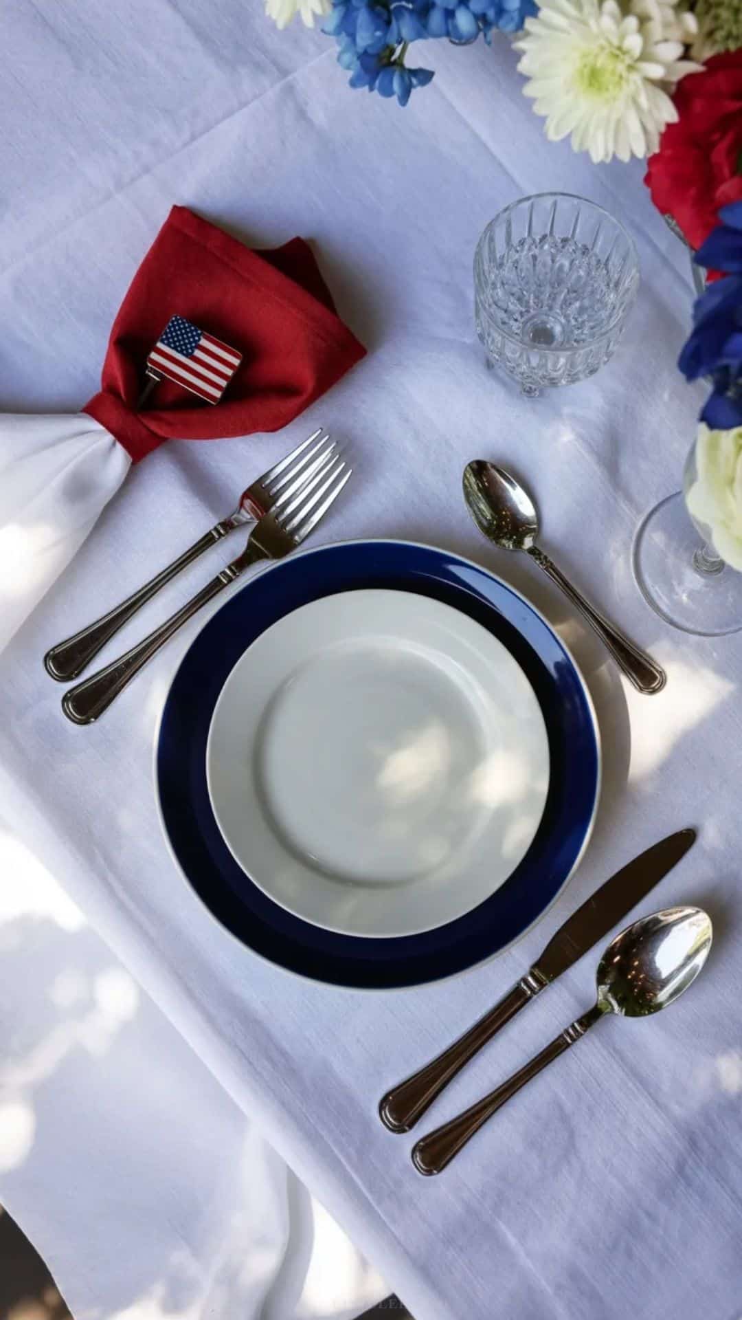 Memorial Day place setting on a white linen tablecloth.