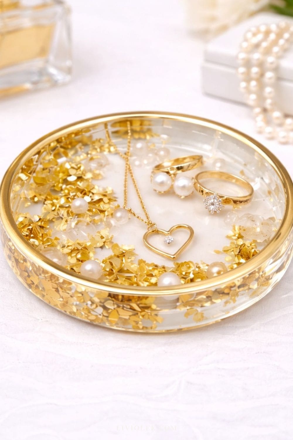 Handmade gold resin trinket dish with pressed flowers and gold flakes, styled with jewelry